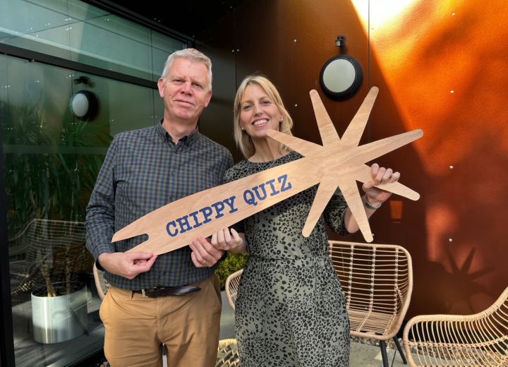 Kata Strawson and Jez Ashberry holding a wooden fork that says 'Chippy Quiz'.